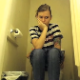 A hidden camera is set up on the floor of a bathroom and records a pretty girl taking a piss and a shit while sitting on a toilet. Plopping sounds are heard. She sneezes and wipes her nose as well. About 5.5 minutes.
